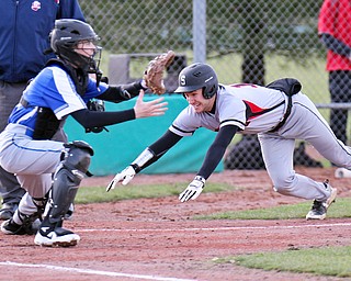 Struthers JD Hall(12) dives for the plate to score during 2nd inning as Poland catcher AndrewTesta(11) waits for the throw during 4-5-18 action at Cene.

William D. Lewis The Vindicator 