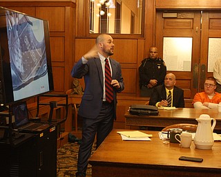 Gabe Wildman, assistant prosecutor, shows photos of clothing from the Jacob LaRosa aggravated murder case while LaRosa in orange and one of his attorneys, David Rouzzo, listen.