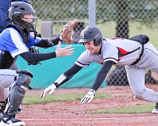 J..D. Hill of Struthers High School dives for the plate to score during the second inning as catcher Andrew Tesla of Poland Seminary High School waits for the throw. Poland defeated Struthers 14-6 on Thursday at Cene Park in Struthers.