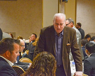 Bob Hannon, standing, President of United Way of Youngstown and the Mahoning Valley, talks with Eric Ryan, sitting left, President of JAC Management Group, at the Youngstown/Warren Regional Chamber of Commerce's "Good Morning, Youngstown" breakfast at Stambaugh Auditorium on Friday, April 6, 2018...Photo by Scott Williams - The Vindicator