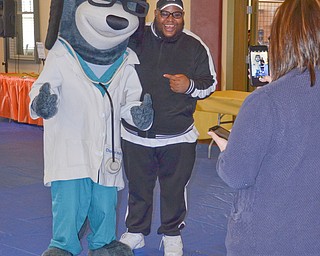 Kaylee Kapalko, Canfield, from United Health Care, takes a photo of Charles "DJ Chip Banks" Colvin, who was providing music, and "Dr. Health E. Hound" at the "Citywide Baby Shower" at the Eugenia Atkinson Recreational Center Saturday, April 7, 2018.

Photo by Scott Williams - The Vindicator