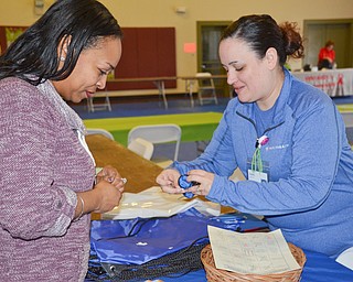 Sara McNicholas, right, from Mercy Health's Center on pregnancy, distributes some free items to Michelle Thomas at the "Citywide Baby Shower" at the Eugenia Atkinson Recreational Center Saturday, April 7, 2018.

Photo by Scott Williams - The Vindicator