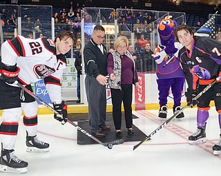 David and Patricia Leo, center, parents of fallen Girard, Ohio Police Officer Justin Leo drop the ceremonial first puck at the Youngstown Phantoms vs. Chicago Steel hockey game at Covelli Centre on Saturday April 7, 2018.  A portion of the night's ticket revenue was donated towards a fund in Justin's name.  Representing Chicago is #22, Matteo Pietroniro, left, and for the Phantoms is #7, Eric Esposito.

Photo by Scott Williams - The Vindicator