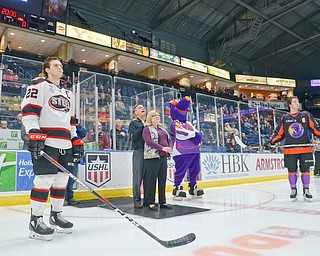 David and Patricia Leo, center, parents of fallen Girard, Ohio Police Officer Justin Leo watch an emotional video about their son prior to dropping the ceremonial first puck at the Youngstown Phantoms vs. Chicago Steel hockey game at Covelli Centre on Saturday April 7, 2018.  A portion of the night's ticket revenue was donated towards a fund in Justin's name.  Representing Chicago is #22, Matteo Pietroniro, left, and for the Phantoms is #7, Eric Esposito.

Photo by Scott Williams - The Vindicator