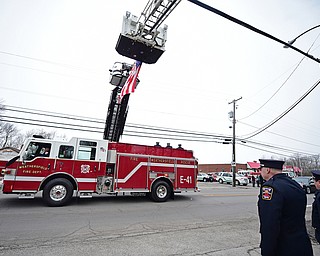 WEATHERSFIELD, OHIO - APRIL 9, 2018: A Weathersfield fire truck transporting Weathersfield Township Fire Chief Randall Pugh's casket passes under the American flag after the conclusion of his funeral, Monday morning. DAVID DERMER | THE VINDICATOR