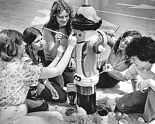 PLUGS GO PATRIOTIC - A number of city fire hydrants are being painted to resemble Revolutionary War patriots as a "plug" for the bicentennial, the project being sponsored by the education committee of the Mahoning-Youngstown Bicentennial Commission.  The artists are (left to right) Terri Prezioso, Janey Martinko, Mary Hulme, Lyn O'Neil, and Rick Schilling.  Miss. Hulme, who supervised the job, is a daughter of MR. and Mrs. Ed Hulme.  Hulme is bicentennial chairman.  The painters are students of William Diana, art instructor at Cardinal Mooney High School.  Paint for the seven-color "patriots" was donated by the O'Brien Corp. through its local distributor, Youngstown Paint & Glass Co.

Photo by Paul R. Schell