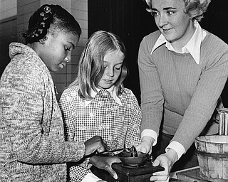 COFFEE MILL - Human energy used to provide the power for grinding.  Trying their hands (left to right) are Sherraine Thomkins and Christine Reisinger with Mrs. J. Walter Dragelevich of the Junior League providing instruction.

Photo published Saturday, November 1, 1975.

Photo by Paul R. Schell.