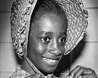 Patricia Mattison, fifth grader, tries a bonnet from the collection when it made a recent visit to Mary Haddow School.

Photo published Saturday, November 1, 1975.

Photo by Paul R. Schell.