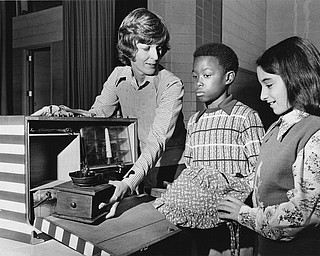 Mark Boyd (center) seems skeptical, but Ream Jadallah already is delighted with the bonnet.

Photo published Saturday, November 1, 1975.

Photo by Paul R. Schell.