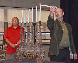 Howard Honigman, a 2nd generation Holocaust survivor, (right) lights one of six candles, each one representing one million of the six million lost during the Holocaust, at a Shoah Memorial Ceremony held at the Jewish Community Center on Sunday, April 15, 2018.  Robert Rawl, (left) awaits his turn.

Photo by Scott Williams - The Vindicator