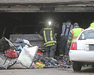 Firefighters and Ohio State Fire Marshals sort through the remains of the gutted garage in the 400 block of Simler Street in Hubbard on Nov. 22. James Vint died of smoke inhalation after becoming trapped in the garage. There is still no cause for how the fire started.