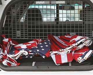 Flags sit in the rear of an Austintown police car. The Mahoning County Veterans Service was busy putting up flags over one of several bridges in Mahoning County. Three bridges are slated to get the flags. They are the state Route 46 overpass in Austintown over interstates 80 and 76; Mahoning Avenue over state Route 11 and state Route 164.