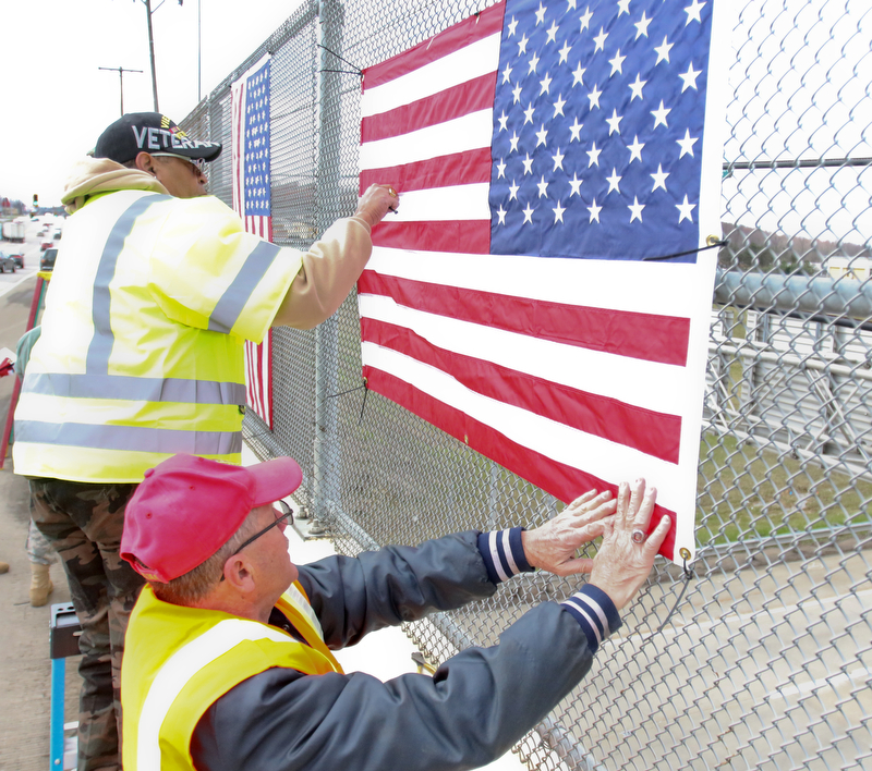 Jerome Givens and Kenny.Jakubek, both veterans, put up hang one of several bridges in Mahoning County. Three bridges are slated to get the flags. They are the state Route 46 overpass in Austintown over interstates 80 and 76; Mahoning Avenue over state Route 11 and state Route 164.