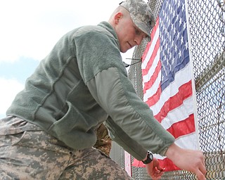 Dustin Bowesock of the 838th military police straightens the flag while placing it on a Mahoning County bridge.
Three bridges are slated to get the flags. They are the state Route 46 overpass in Austintown over interstates 80 and 76; Mahoning Avenue over state Route 11 and state Route 164.
