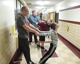 Neighbors | Zack Shively.The father/child gym night at Stadium Elementary allowed dads to spend time with their children and meet their children's friends and other dads with children in the school. Pictured, two dads helped their sons with yoga poses during the scavenger hunt.