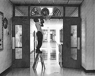 PREPARING FOR BUSH - St. Luke student Joe Cassese, 13, decorates the halls early Thursday morning preparing for a visit from Mrs. Bush. 

 Photo taken September 17, 1992. 

 Photo by Doug Oster - The Vindicator