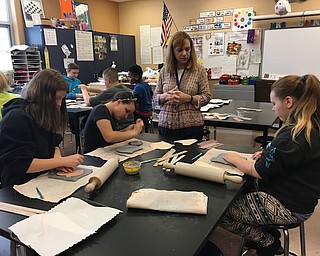 Brookfield sixth-graders in Linda Bain’s art class created clay masks of animals or humans inspired by other cultures. They added textures and raised features, such as eyes, nose and mouth. They also painted the masks and added glaze before they were fired in a kiln. Finished masks were displayed in the classroom. Above, Mrs. Bain instructs students on how to build up the clay to add dramatic features. Below are Tara Thompson, left, and Charles Nicholson, who are adding texture to their masks.
