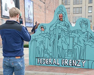 Tim Long takes a photo of his parents, mother Jean (on the left) and father Mike who are sticking their faces through a wooden face-cutout-board at the Federal Frenzy Music and Arts Festival on West Federal Street in downtown Youngstown on Saturday, April 21, 2018.  

Photo by Scott R. Williams - The Vindicator