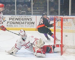 Phantoms penalty killer Matthew Barry looks back to see the puck in the net behind Fighting Saints goaltender Cole Weaver during Saturday’s USHL playoff game at the Covelli Centre. Trailing is Saints forward Alex Steeves. Youngstown won, 3-2.