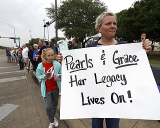 Kelly Yates holds up a sign as she waits on the route for the motorcade carrying former first lady Barbara Bush, Saturday, April 21, 2018, in College Station, Texas. (AP Photo/Mark Humphrey)