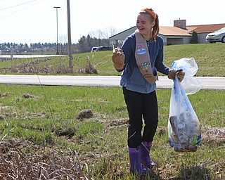 Katie Padgett of the Girl Scout Troop 80095 of Canfield cleans up plastic found in the Mill Creek Preserve on Western Reserve Road in Boardman on Saturday morning.  Dustin Livesay  |  The Vindicator  4/21/18