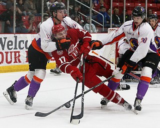 Youngstown Phantoms' Jack Malone (left) and Curtis Hall (right) knock Dubuque Fighting Saints' Tyce Thompson off his feet during their hockey game at Mystique Community Ice Center in Dubuque on Tuesday, April 24, 2018.