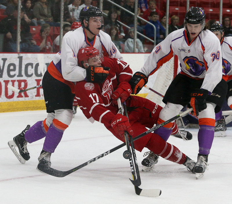 Youngstown Phantoms' Jack Malone (left) and Curtis Hall (right) knock Dubuque Fighting Saints' Tyce Thompson off his feet during their hockey game at Mystique Community Ice Center in Dubuque on Tuesday, April 24, 2018.