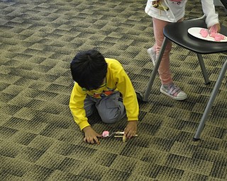 Neighbors | Zack Shively.The children tried each of the stations at the Austintown library's Marshmallow Peep Science program, and they went to their favorite stations during the end of the program. Pictured, the children used a catapult to launch Peeps into Easter baskets.