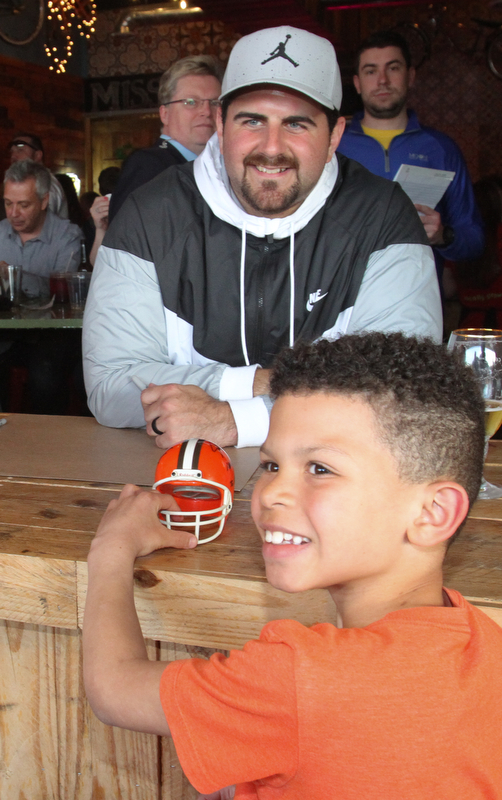 William D. Lewis The Vindicator Brian Briggs, 9, of Youngstown poses for a photo with NFL star John Greco during draft night event at Suzies Dogs and Drafts in Boardman.