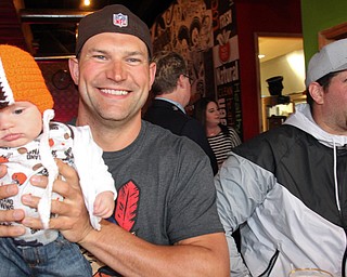 William D. Lewis The Vindicator Haden Holmes, 13 weeks, meets former Browns player Joe Thomas, at left  NFL star John Greco during draft night event at Suzies Dogs and Drafts in Boardman. Haden is a son of Matt and Samantha Holmes of Austintown.