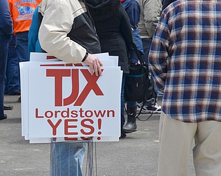 Dan Crouse, from Warren, (left) passes out pro TJX yard signs to attendees at a rally to keep TJX in the Mahoning Valley on Sunday, April 29, 2018 at the Lordstown High School track. 

Photo by Scott R. Williams - The Vindicator