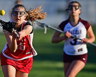 BOARDMAN, OHIO - APRIL 30, 2018: Canfield's Clare Crescimanno looks the ball into her stick while being pressured by Boardman's Lauren Fetsko during the first half of their game on Monday night at Spartan Stadium. DAVID DERMER | THE VINDICATOR