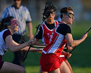 BOARDMAN, OHIO - APRIL 30, 2018: Canfield's Oliva Vandevender looks the ball into her stick while being pressured by Boardman's Colleen Yambar during the first half of their game on Monday night at Spartan Stadium. DAVID DERMER | THE VINDICATOR