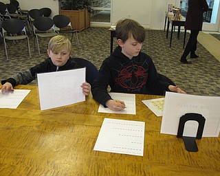 Neighbors | Zack Shively.The "Detectives Wanted" library program featured fingerprinting, ISpy activities, a scavenger hunt and "code breakers." Pictured, Harlan and Remington Fish broke codes using a grid key code.