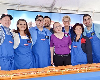 The ribbon is cut, or in this case, a gigantic sub sandwich is cut at the grand-opening ceremony of the new GetGo gas station/cafe/market at 133 Boardman-Poland Road in Boardman on Thursday May 3, 2018.   From left to right, there is Rochelle Lawrence, Lelah Hogan, Craig Rotz, Adam Richman - celebrity chef, Amber Tracy, Polly Flinn - GetGo senior vice president and general manager, Sharon Hrina - Akron Children's Hospital, and Christ Wolfe. 

Photo by Scott Williams - The Vindicator