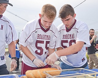 Members of the Boardman High School Lacrosse team, from left to right, #9 - Devin Whitaker, #55 - Clayton Wehr, and #50 - Cody Geary, participated in a "Sub Off" challenge, racing each other to make the most subs in three minutes at the grand-opening ceremony of the new GetGo gas station/cafe/market at 133 Boardman-Poland Road in Boardman on Thursday May 3, 2018. 

Photo by Scott Williams - The Vindicator