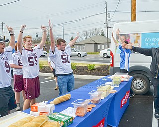 Members of the Boardman High School Lacrosse team, from left to right, #9 - Devin Whitaker, #55 - Clayton Wehr, and #50 - Cody Geary, participated in a "Sub Off" challenge, racing each other to make the most subs in three minutes at the grand-opening ceremony of the new GetGo gas station/cafe/market at 133 Boardman-Poland Road in Boardman on Thursday May 3, 2018.  On the right in black is celebrity chef Adam Richman. 

Photo by Scott Williams - The Vindicator