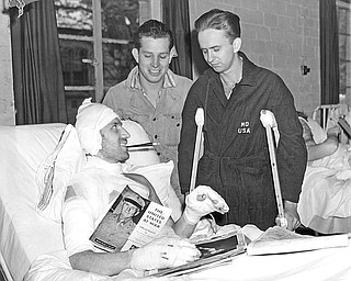 Three Ohioans recovering in an Army hospital in England, May 10, 1944, from left to right are; Sergeant Dewey T. Brucoli, in bed, Youngstown, Ordnance man; Private Woodrow W. Coulter, Lima, Infantryman; and Pfc. Park Williams,  Cleveland, engineer. (AP File Photo)