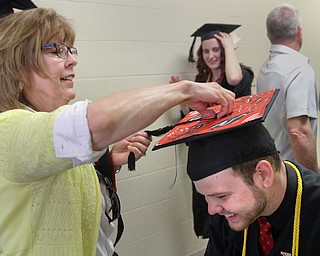 William D. Lewis The Vindicator  Nicholas Dean of New Waterford gets some help with his tassle from Pat Miller, a YSU volunteer, before 5-5-18 graduation.