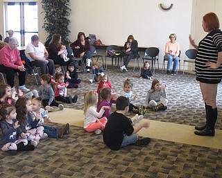 Neighbors | Zack Shively.Mallory Wiand led the children through a couple well-known children's songs. They all sang the songs, such as the nursey rhyme "The Itsy Bitsy Spider" and "The Grand Old Duke of York," and did little motions to go along with the songs. Pictured, they all honked the bus horn during their singing of "The Wheels on the Bus."