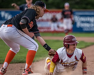 THE VINDICATOR | DIANNA OATRIDGEÊ Cardinal Mooney's Ethan Shaw avoids a pick off attempt by Howland's Dylan Keller during their Division II Sectional Final match-up at Cene Park on Wednesday. The Cardinals won the game 11-2.