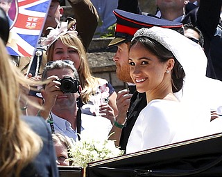 Britain's Prince Harry and Meghan Markle leave in an open carriage after their wedding ceremony  at St. George's Chapel in Windsor Castle in Windsor, near London, England, Saturday, May 19, 2018. (Chris Radburn/pool photo via AP)