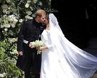 Britain's Prince Harry and Meghan Markle kiss as they leave after their wedding at St. George's Chapel in Windsor Castle in Windsor, near London, England, Saturday, May 19, 2018. (Andrew Matthews/pool photo via AP)