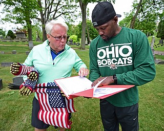 YOUNGSTOWN, OHIO - MAY 19, 2018: John Freeze of Poland, left, and Carlos Jones of Youngstown look in their book of cemetery plots to see where the resting place of a serviceman is to place an American flag near, Saturday morning at the Oak Hill Cemetery. DAVID DERMER | THE VINDICATOR