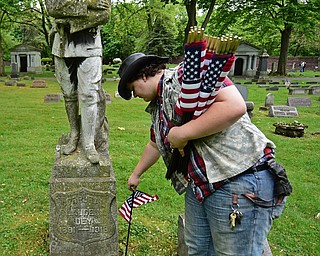 YOUNGSTOWN, OHIO - MAY 19, 2018: Clayton Henderson of Youngstown places an American flag near the grave of a serviceman who passed away during World War One, Saturday morning at the Oak Hill Cemetery. DAVID DERMER | THE VINDICATOR