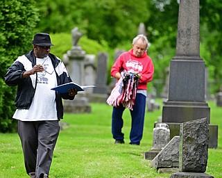 YOUNGSTOWN, OHIO - MAY 19, 2018: Steffon Jones of Youngstown, one of the event organizers, front, and Tim Danner of Youngstown work together while placing US flags at the resting places for former servicemen, Saturday morning at the Oak Hill Cemetery. DAVID DERMER | THE VINDICATOR