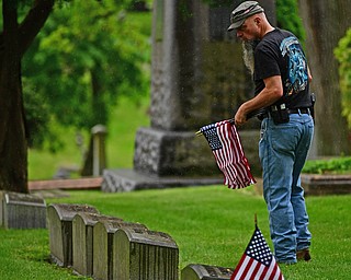 YOUNGSTOWN, OHIO - MAY 19, 2018: Chip Proffit of Youngstown carries American flags while looking for a grave site to place one, Saturday morning at the Oak Hill Cemetery. DAVID DERMER | THE VINDICATOR