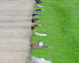 YOUNGSTOWN, OHIO - MAY 19, 2018: Shoes that belonged to someone from Mahoning County line the sidewalk of Wick Park, Saturday afternoon. DAVID DERMER | THE VINDICATOR