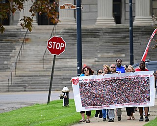 YOUNGSTOWN, OHIO - MAY 19, 2018: Hope Anne Youngstown the Mahoning County Coordinator for Ohio Can, James Garltic of Niles and Youngstown Mayor Jamael Tito Brown walk on the sidewalk in Wick Park earring a poster with the pictures of people who have passes away from opioid overdoses, Saturday afternoon. DAVID DERMER | THE VINDICATOR