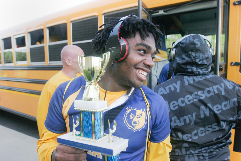 William D. Lewis the Vindicator   East HS 10th grade rugby player Elija smith carries the trophy as the team returns to the school 5-20-18 after beating Shaker Hgts to win the state championship.